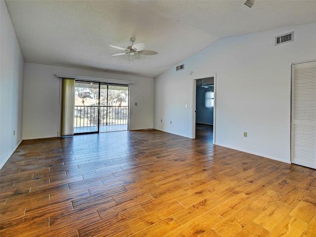 unfurnished room with visible vents, a ceiling fan, lofted ceiling, and wood finished floors