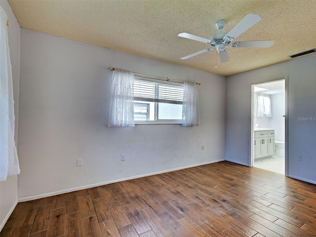 spare room featuring ceiling fan, a textured ceiling, visible vents, and wood finished floors