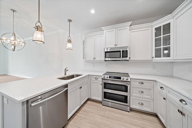 555 N Orange Ave Unit 307, Sarasota, FL 34236 - kitchen with stainless steel appliances, a sink, light countertops, a peninsula, and glass insert cabinets