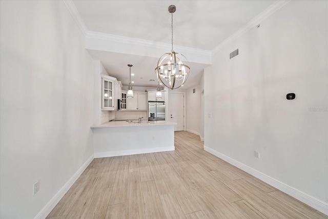 555 N Orange Ave Unit 307, Sarasota, FL 34236 - unfurnished living room featuring a chandelier, baseboards, light wood finished floors, a sink, and ornamental molding
