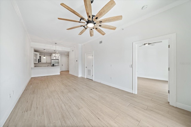555 N Orange Ave Unit 307, Sarasota, FL 34236 - unfurnished living room featuring ceiling fan, light wood-style floors, a chandelier, baseboards, and ornamental molding