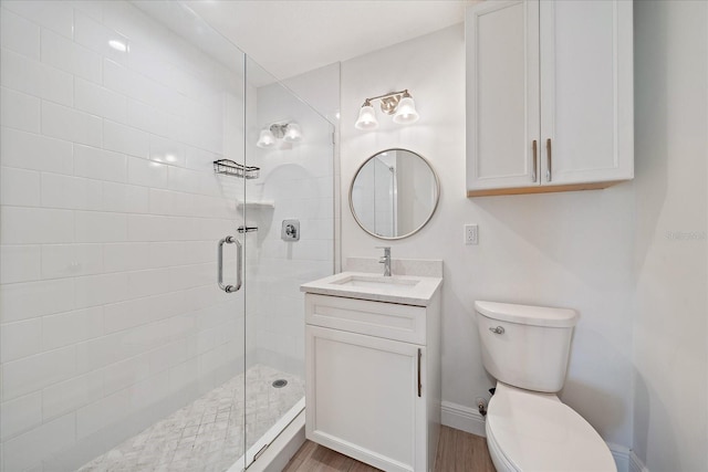 555 N Orange Ave Unit 307, Sarasota, FL 34236 - bathroom featuring a stall shower, toilet, vanity, wood finished floors, and baseboards
