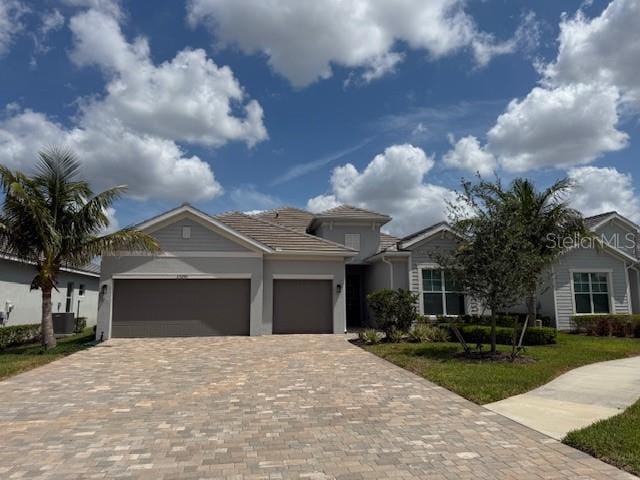 view of front facade with a garage and decorative driveway