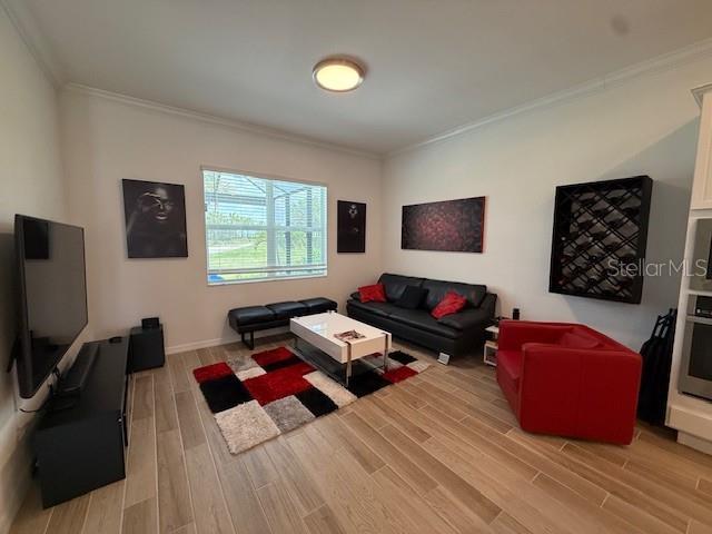 living area with light wood finished floors and ornamental molding