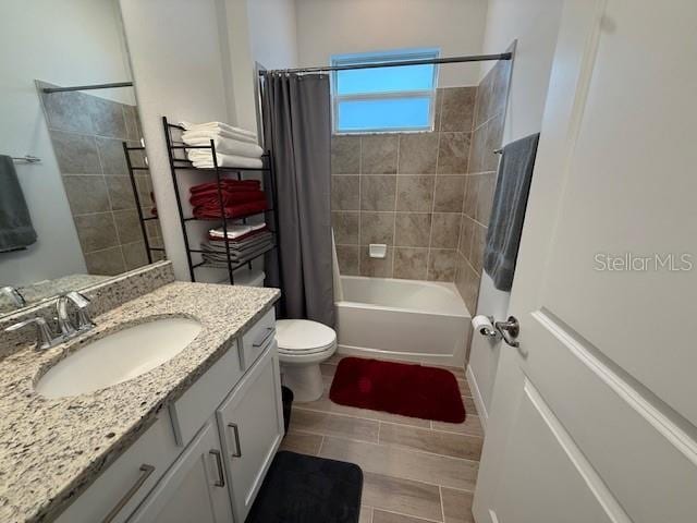 full bath with shower / bath combo with shower curtain, toilet, and vanity