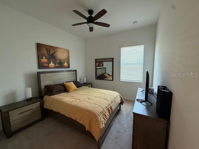 bedroom with a ceiling fan and carpet floors