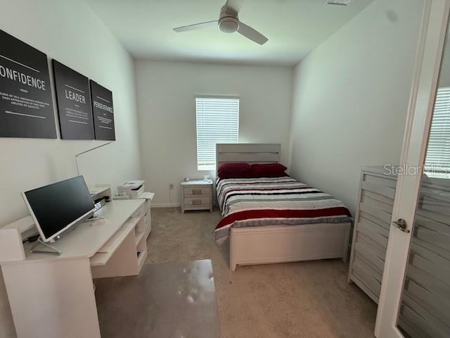 carpeted bedroom featuring visible vents and ceiling fan