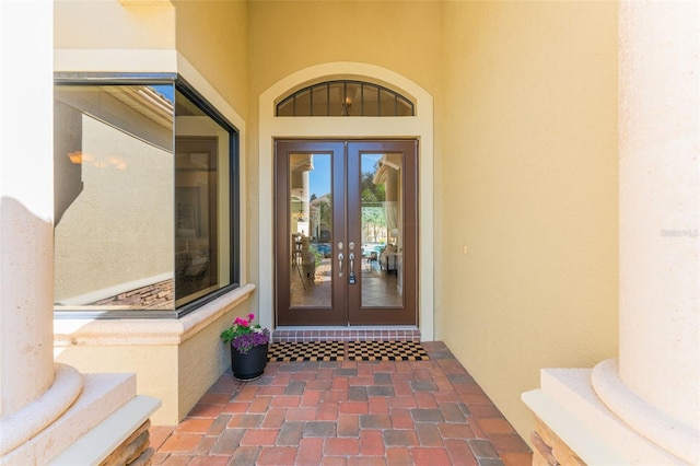 view of exterior entry featuring stucco siding and french doors