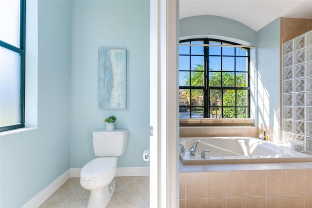 bathroom with a garden tub, baseboards, tile patterned flooring, and toilet