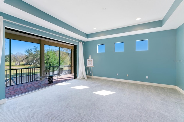 carpeted spare room with recessed lighting, baseboards, and a raised ceiling