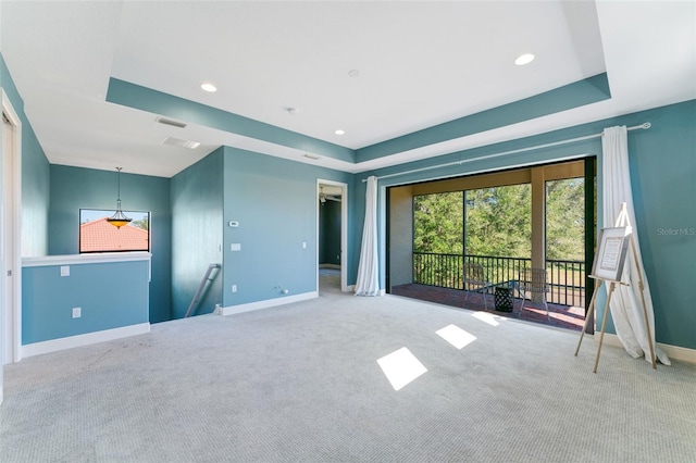 unfurnished room featuring recessed lighting, baseboards, a tray ceiling, and carpet