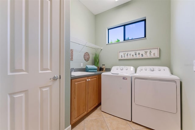 clothes washing area with cabinet space, a sink, washing machine and dryer, and light tile patterned floors