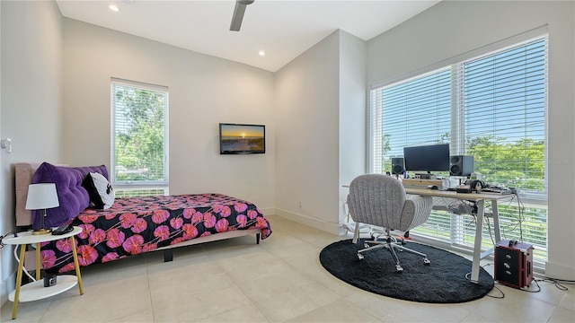 tiled bedroom with ceiling fan and baseboards
