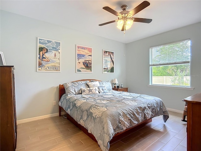 bedroom with baseboards, light wood-style floors, and ceiling fan