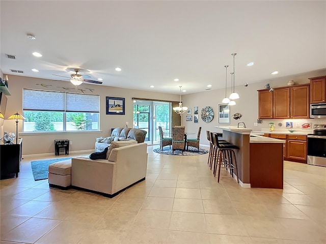 living room with light tile patterned flooring, recessed lighting, a chandelier, a ceiling fan, and baseboards