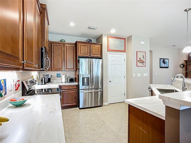 kitchen featuring stainless steel appliances, a sink, light countertops, hanging light fixtures, and recessed lighting