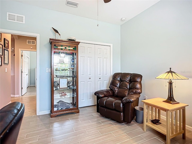 sitting room with wood tiled floors, baseboards, and ceiling fan