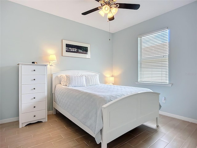 bedroom with baseboards, wood tiled floors, and ceiling fan