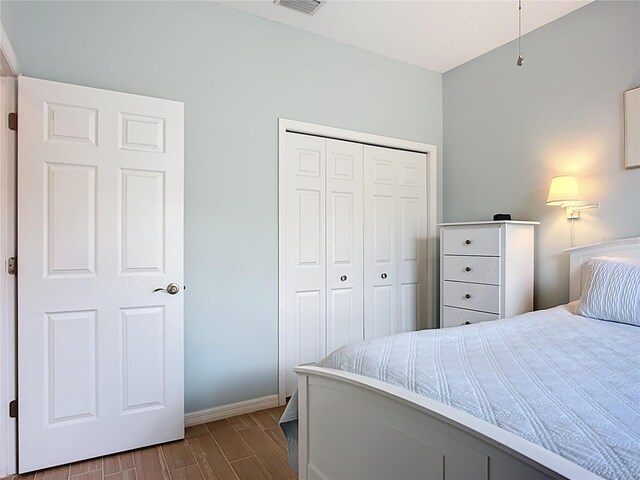 bedroom with a closet, baseboards, and wood finish floors