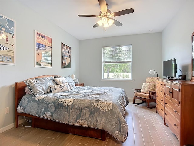 bedroom with light wood-type flooring, baseboards, and a ceiling fan