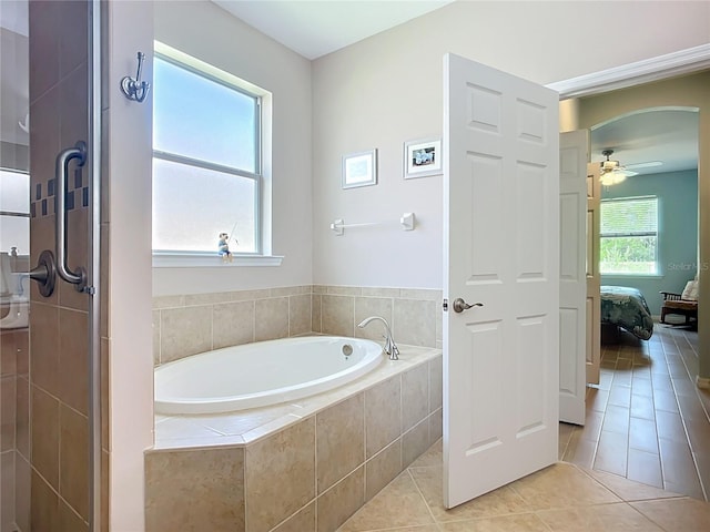 full bathroom featuring tile patterned flooring, a bath, a ceiling fan, a tile shower, and ensuite bathroom