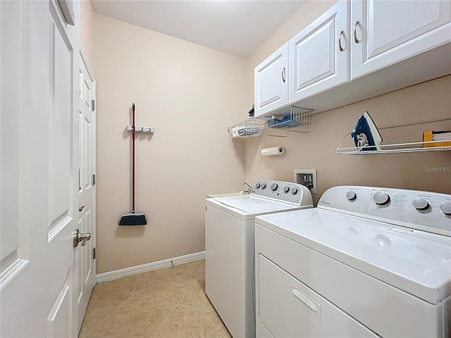 laundry area featuring cabinet space, separate washer and dryer, baseboards, and light tile patterned flooring