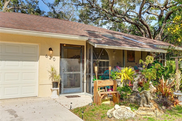 620 Burke Rd, Venice, FL 34293 - doorway to property featuring concrete driveway, stucco siding, roof with shingles, and a garage