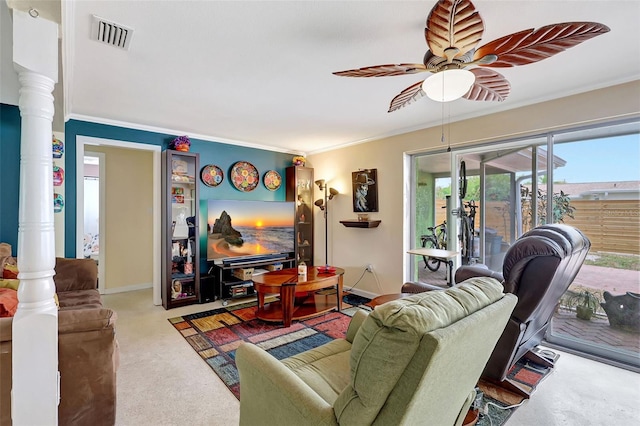 carpeted living area with visible vents, a ceiling fan, crown molding, and ornate columns