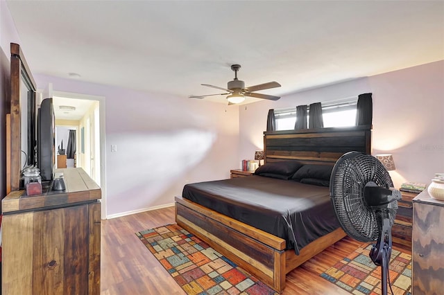 bedroom with baseboards, ceiling fan, and wood finished floors
