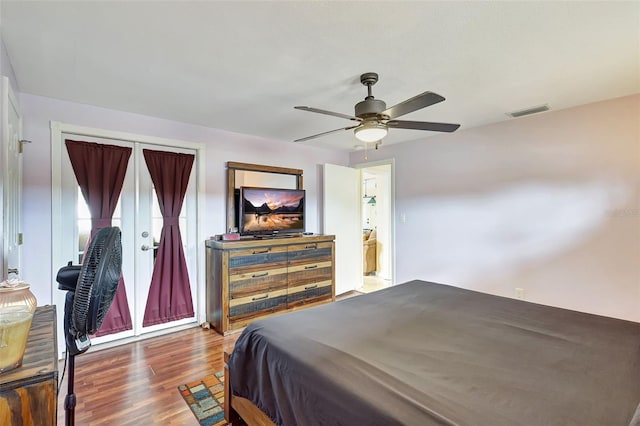 bedroom with a ceiling fan, visible vents, and wood finished floors