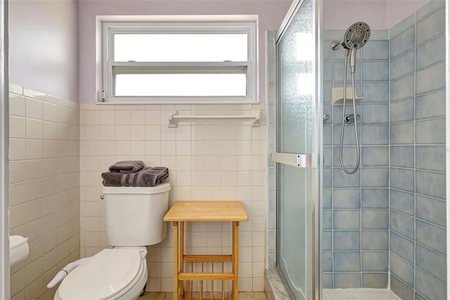 full bath featuring a stall shower, toilet, and tile walls