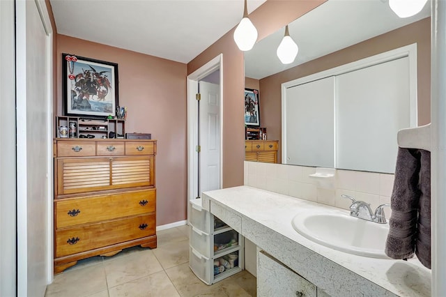 bathroom featuring vanity, tile patterned floors, baseboards, and tasteful backsplash