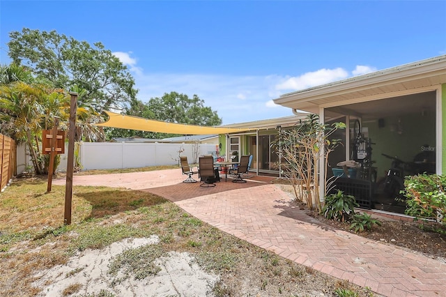view of yard featuring a fenced backyard, a sunroom, and a patio area
