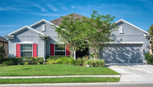 11924 Persian Ter, Bradenton, FL 34212 - view of front of house featuring stucco siding, an attached garage, a front lawn, and driveway