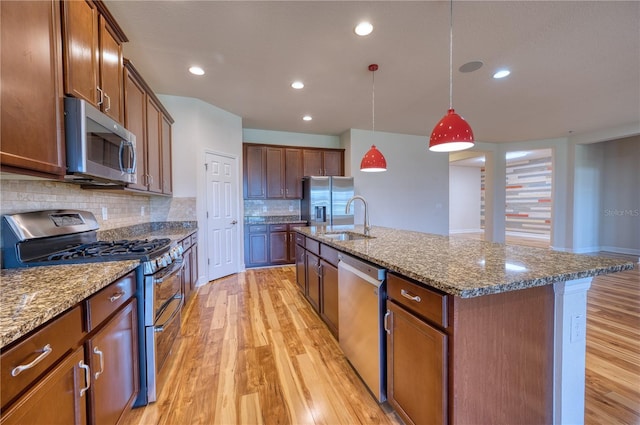 11924 Persian Ter, Bradenton, FL 34212 - kitchen featuring stainless steel appliances, a sink, light wood-style floors, dark stone counters, and recessed lighting