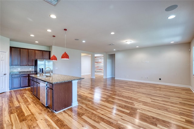 11924 Persian Ter, Bradenton, FL 34212 - kitchen featuring appliances with stainless steel finishes, a sink, light wood-style flooring, a kitchen island with sink, and recessed lighting