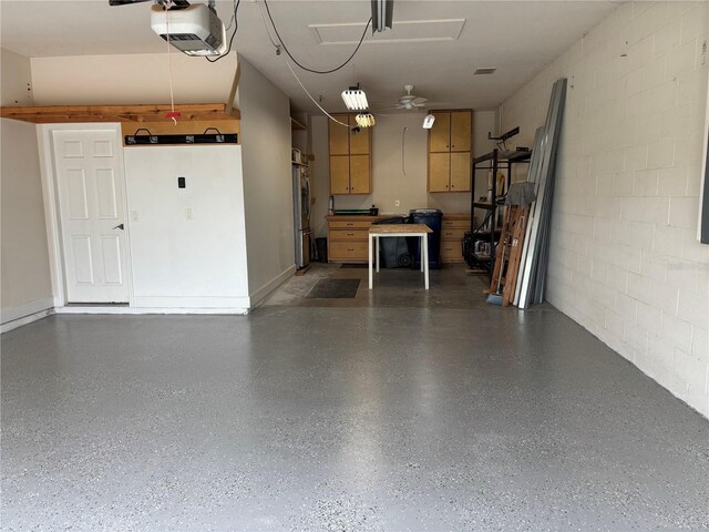 11924 Persian Ter, Bradenton, FL 34212 - garage featuring stainless steel fridge, concrete block wall, and a garage door opener