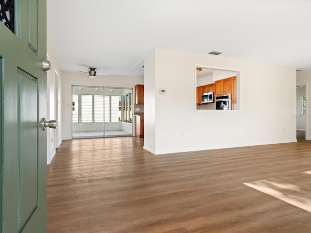 6116 Rodgers Ave, Sarasota, FL 34231 - unfurnished living room with ceiling fan, baseboards, visible vents, and wood finished floors