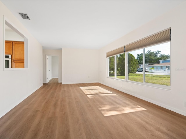6116 Rodgers Ave, Sarasota, FL 34231 - unfurnished living room featuring visible vents, baseboards, and light wood finished floors