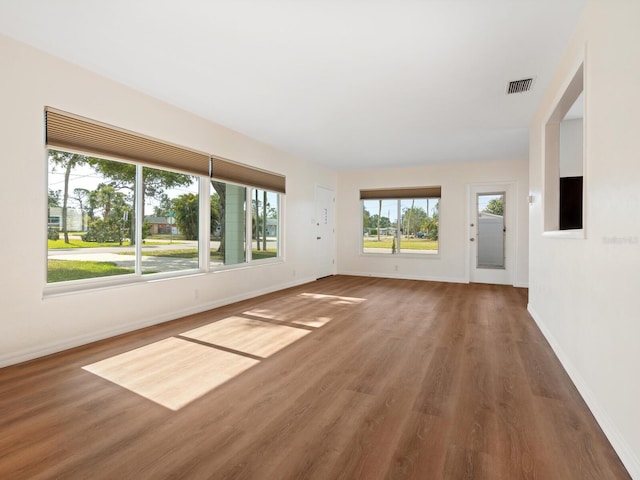 6116 Rodgers Ave, Sarasota, FL 34231 - unfurnished living room with baseboards, wood finished floors, and visible vents