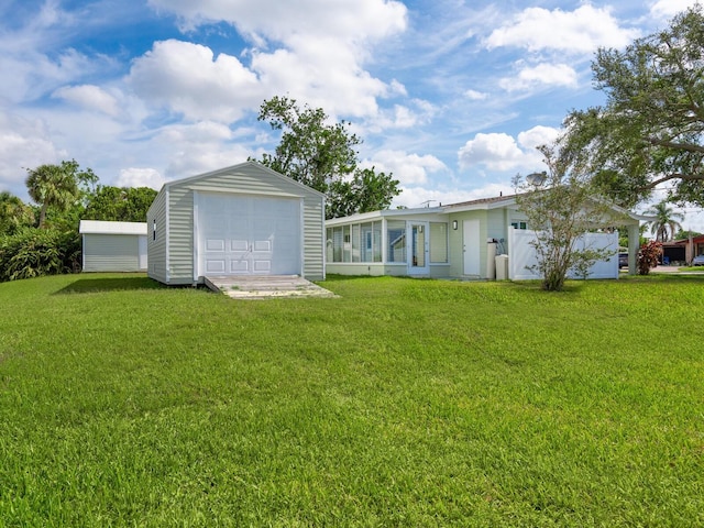 6116 Rodgers Ave, Sarasota, FL 34231 - rear view of property featuring a garage, an outdoor structure, and a yard