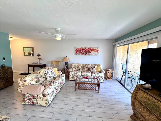 living room featuring wood tiled floor, a textured ceiling, and a ceiling fan