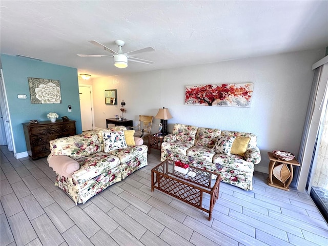 living area featuring wood tiled floor and a ceiling fan