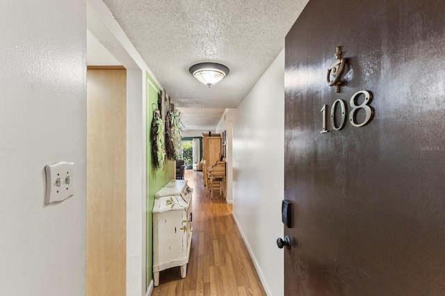 4015 Lake Bayshore Dr Unit 108, Bradenton, FL 34205 - hallway with a textured ceiling, baseboards, and wood finished floors