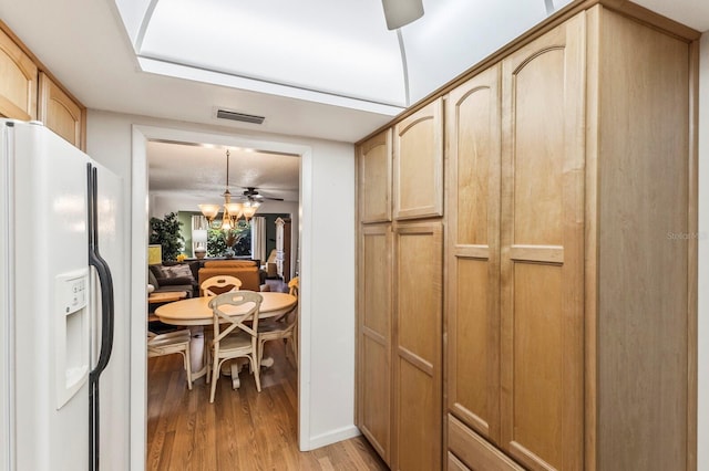 4015 Lake Bayshore Dr Unit 108, Bradenton, FL 34205 - kitchen with white fridge with ice dispenser, visible vents, light wood-style flooring, light brown cabinetry, and a ceiling fan