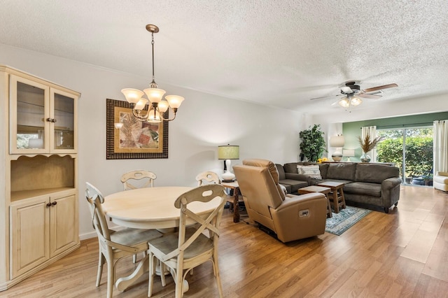 4015 Lake Bayshore Dr Unit 108, Bradenton, FL 34205 - interior space featuring light wood-type flooring, a textured ceiling, and ceiling fan with notable chandelier