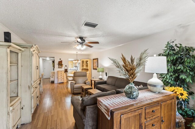 4015 Lake Bayshore Dr Unit 108, Bradenton, FL 34205 - living area featuring a textured ceiling, visible vents, light wood-style flooring, and ceiling fan