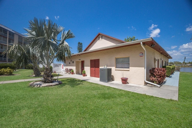 4015 Lake Bayshore Dr Unit 108, Bradenton, FL 34205 - rear view of property featuring stucco siding, central AC unit, and a lawn