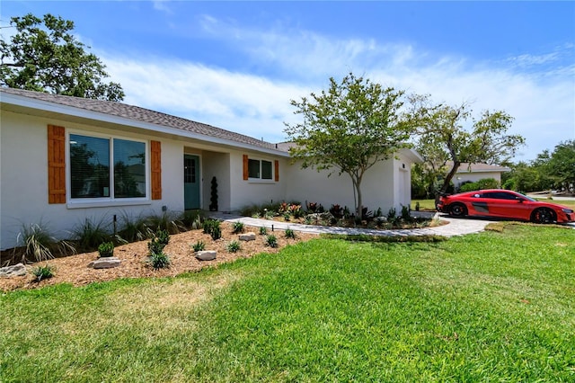 ranch-style home featuring stucco siding and a front yard