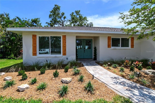 ranch-style home with french doors and stucco siding
